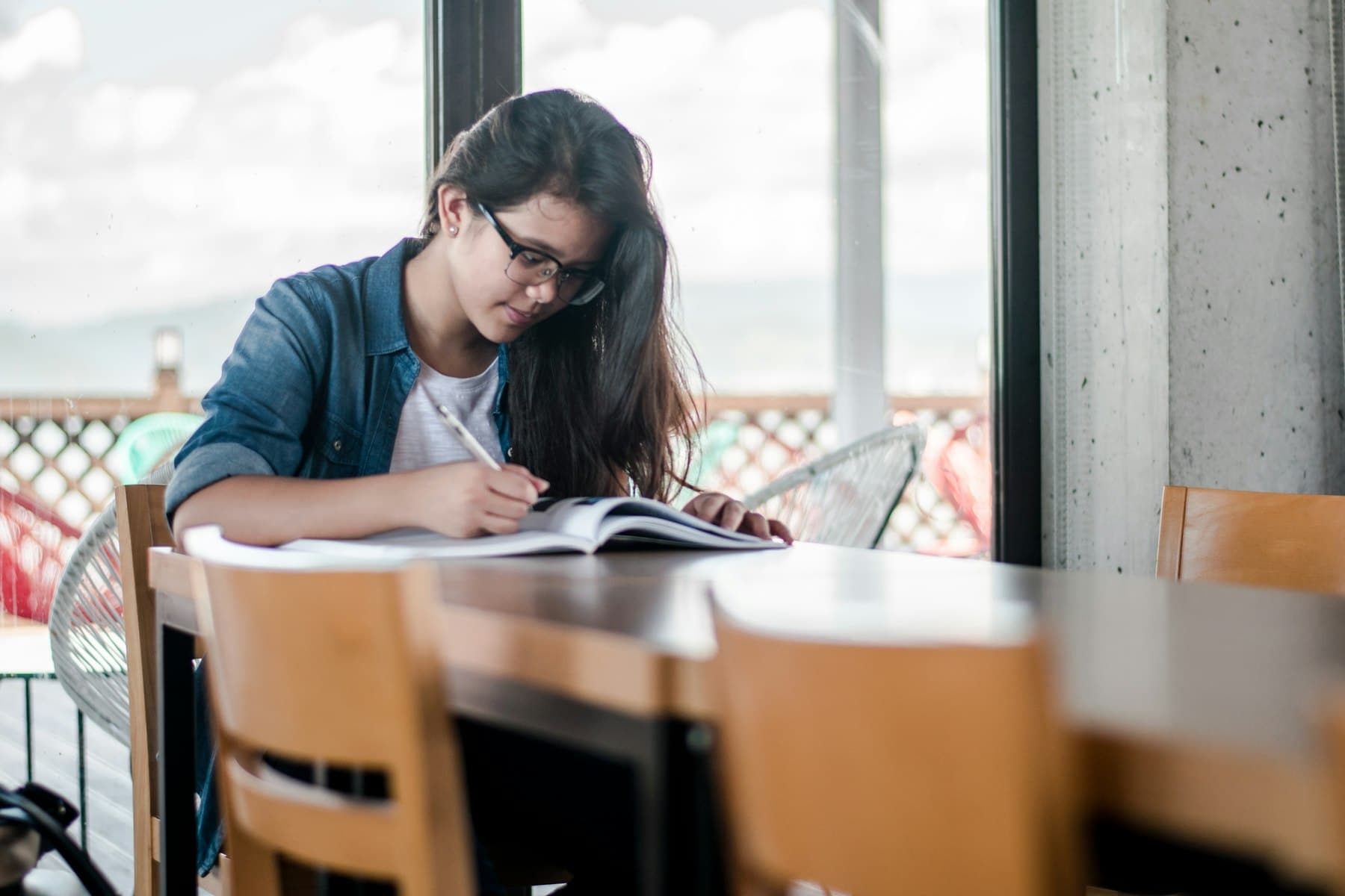 A student writing notes at a café table